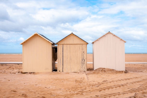 Three beach huts at the coast of Ouistreham, France Horizontal image of 3 beach-huts with blue sky with white clouds calvados stock pictures, royalty-free photos & images