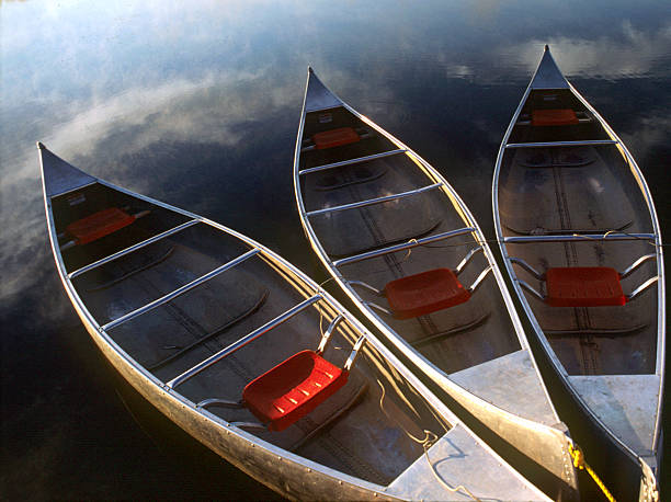 Three Canoes Floating in Calm Water  olathe kansas stock pictures, royalty-free photos & images