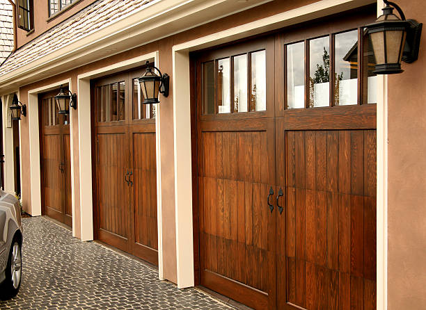 Three Car Garage Image of three seperate garage doors on a luxury home house   neighborhood  wood stock pictures, royalty-free photos & images