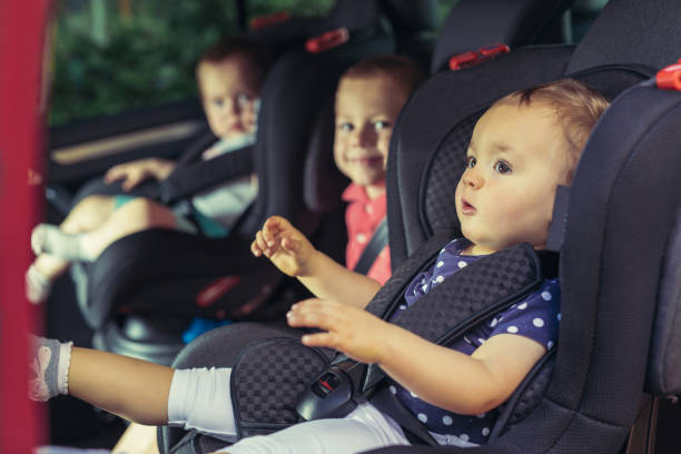Three children in car safety seat Three children in car safety seat - family, transport, safety, road trip and people concept car safety seat stock pictures, royalty-free photos & images