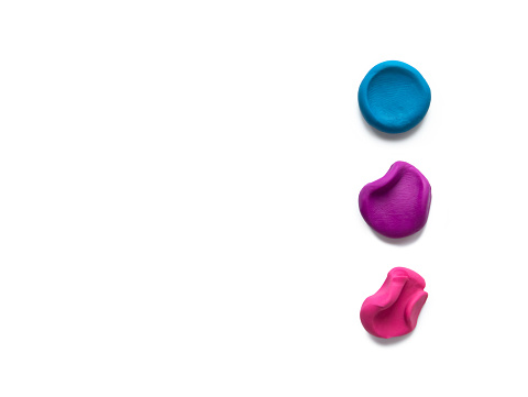 Three color modeling clay plasticine finger textured flatten and crumpled balls or lumps isolated on white background with shadow. Top view, copy space. Stage concept.