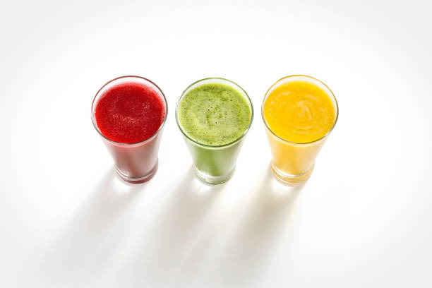 Three colorful fruit smoothies Three colorful fruit smoothies, mango, grape, melon, cabbage, beetroot, lime, on a white background with shadow projection papaya smoothie stock pictures, royalty-free photos & images