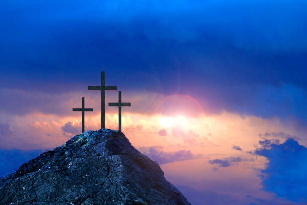 Three Crosses On A Hill At Sunrise Three crosses sit on a rocky hill as they are silhouetted against a rising sun and symbolize the Crucifixion of Christ.  In the distance the sun creeps above the horizon. good friday stock pictures, royalty-free photos & images