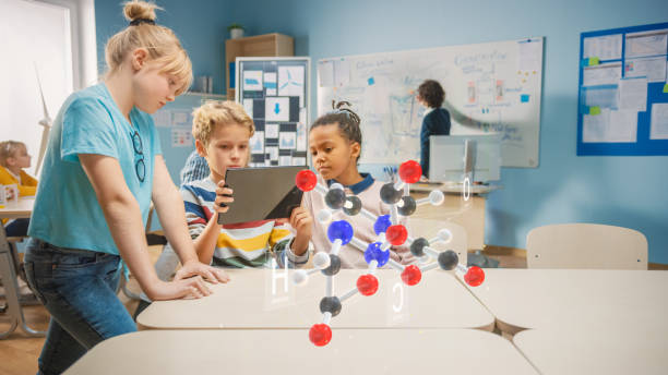 Three Diverse School Children in Chemistry Science Class Use Digital Tablet Computer with Augmented Reality Application, Looking at Educational 3D Animation of a Molecule. VFX, Special Effects Render Three Diverse School Children in Chemistry Science Class Use Digital Tablet Computer with Augmented Reality Application, Looking at Educational 3D Animation of a Molecule. VFX, Special Effects Render digital animation stock pictures, royalty-free photos & images