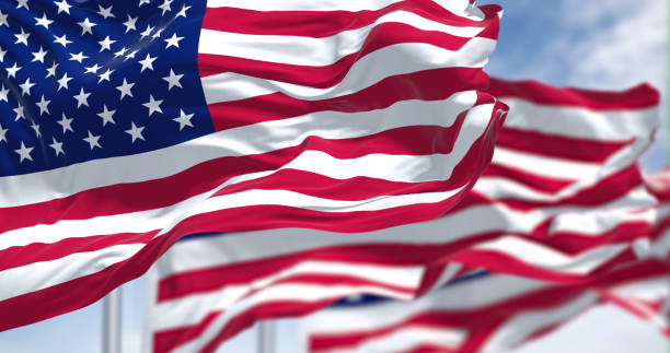 Three flags of the United States of America waving in the wind stock photo