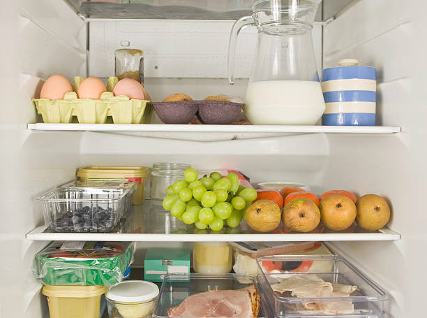 Three fridge shelves full of food stock photo