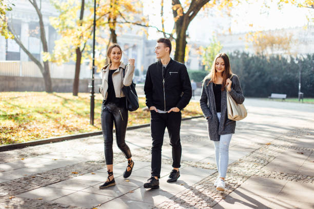 drie vrienden lopen op straat - walking with coffee stockfoto's en -beelden