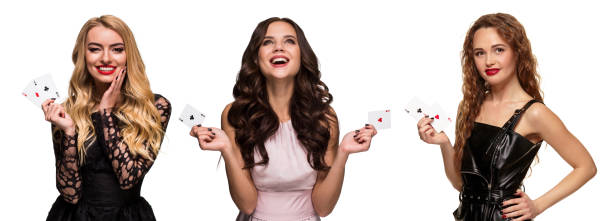 Three girls with make-up and hairstyles, in pink and black dresses, jewelry. Smiling, showing aces, posing isolated on white. Poker, casino. Close-up Three charming girls with make-up and stylish hairstyles, in pink and black dresses, jewelry. Smiling, showing winning combination of aces, posing isolated on white. Poker, casino. Close-up, collage casino girl stock pictures, royalty-free photos & images