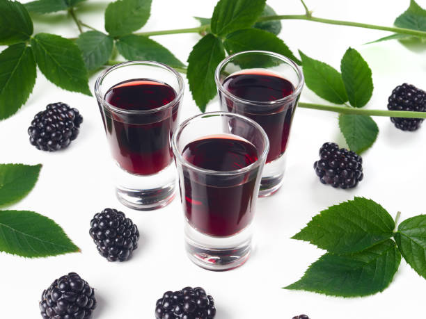 Three glasses of blackberry liqueur, also known as creme de mure stock photo