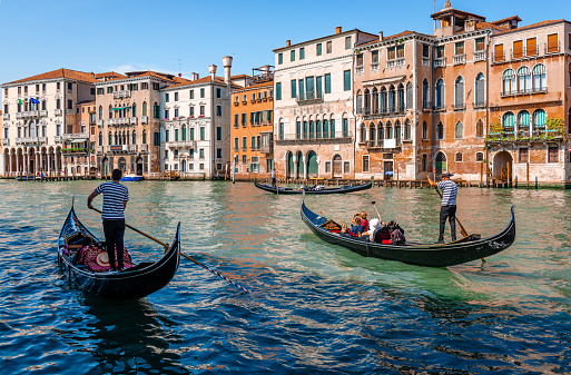 Venice, Italy - May 25 2018: Three gondolas carrying tourists on the Grand Canal. Scenic venetian landscape.