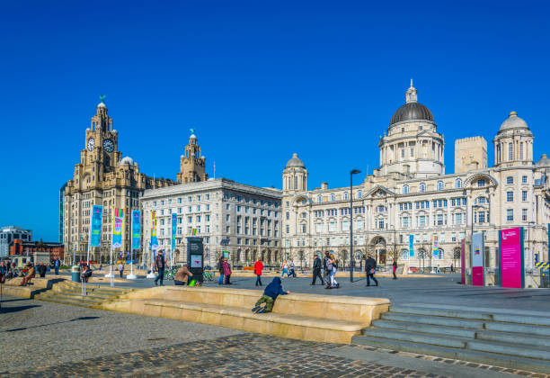 Three Graces buildings in Liverpool, England Liverpool, UK, April 7, 2017: People are walking in front of Three Graces buildings in Liverpool, England cunard building liverpool stock pictures, royalty-free photos & images