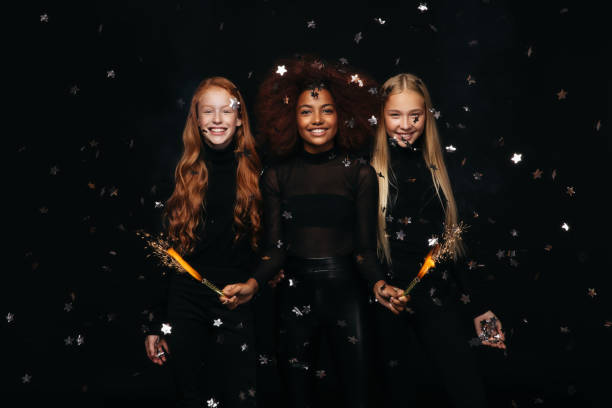 Three happy young girls celebrates New Year Three happy young girls celebrates New Year new years eve girl stock pictures, royalty-free photos & images