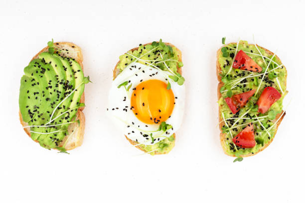Three healthy toasts Three healthy toasts with egg, avocado, micro greens and tomatoes. Breakfast or healthy eating concept, plant based food. Flat-lay, top view. toasted bread stock pictures, royalty-free photos & images