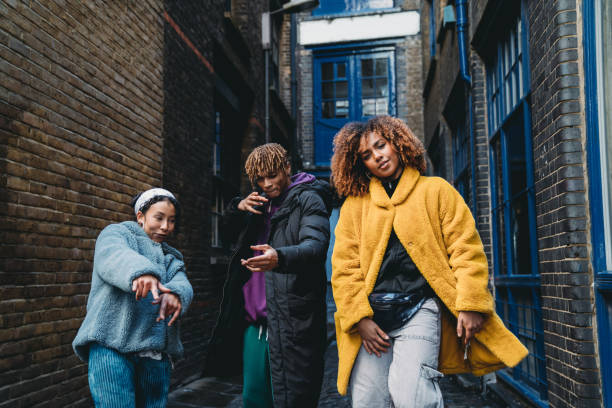 Three hip friends dancing together outdoor in the city Three hip friends dancing together outdoor in the city. Mixed race and african ethnicities. Shoreditch, London. rapper stock pictures, royalty-free photos & images