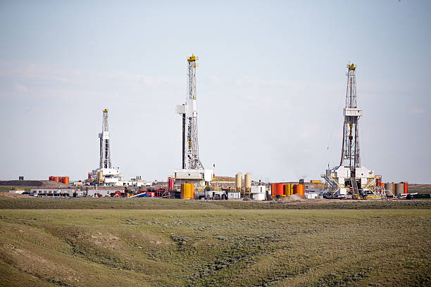 Three hydro- fracking derricks drilling natural gas on a plain stock photo