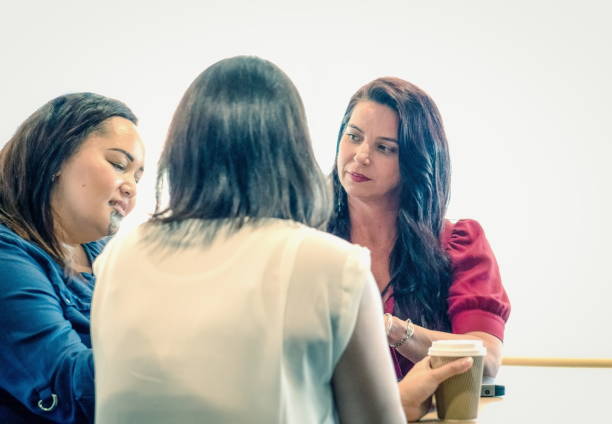 Three New Zealand businesswomen in the work environment having a meeting. stock photo