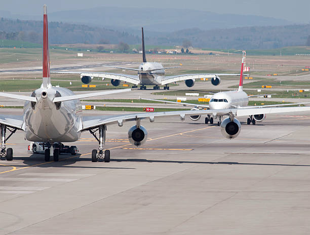 Three passenger aircrafts in heavy traffic on the ground Three passenger aircrafts in heavy traffic on the taxiway of Zurich international airport. Aircraft types on picture include  Airbus A380 (middle). Two moving away, one approaching. Looks like the aircrafts are deadlocked in a taxiway traffic jam. airfield photos stock pictures, royalty-free photos & images
