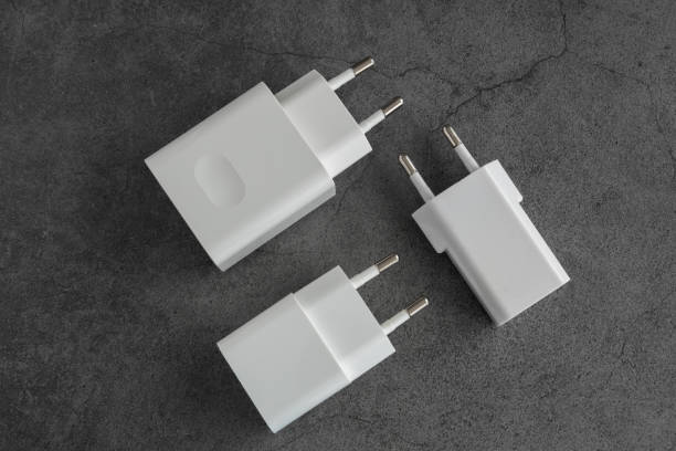 Three phone or tablet chargers on dark background stock photo