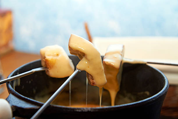 Three skewers of cheese fondue stock photo