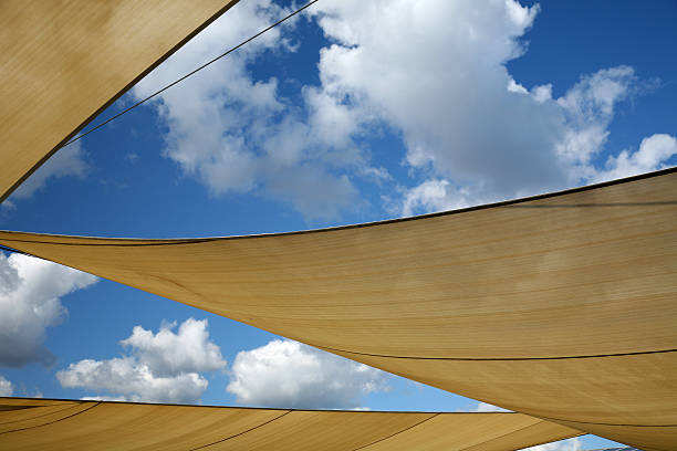 Three sun shade sails against a blue sky stock photo