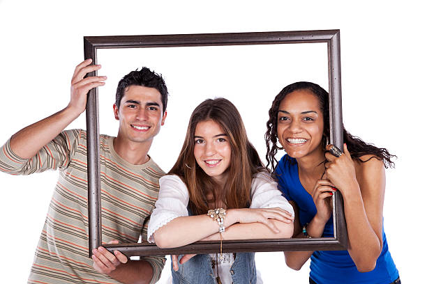 Three teenaged friends posing in a picture frame stock photo
