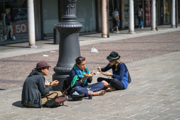 tre turisti che cenano mentre sono seduti per strada a ferrera - giuliano ferrara foto e immagini stock