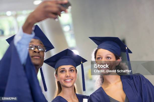 Three university students taking selfie after graduation ceremony