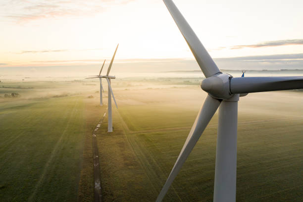 Three wind turbines at sunrise Aerial view of three wind turbines in the early morning fog at sunrise in the English countryside renewable energy stock pictures, royalty-free photos & images