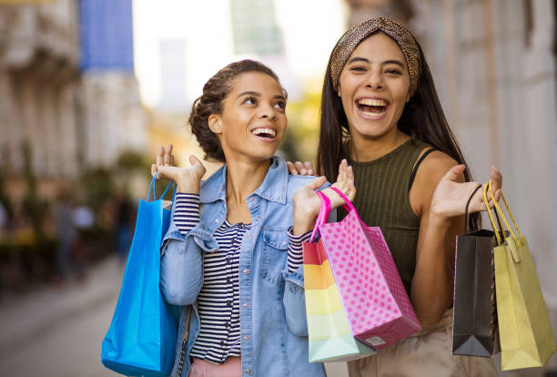 Three women on the street with shopping bags. stock photo