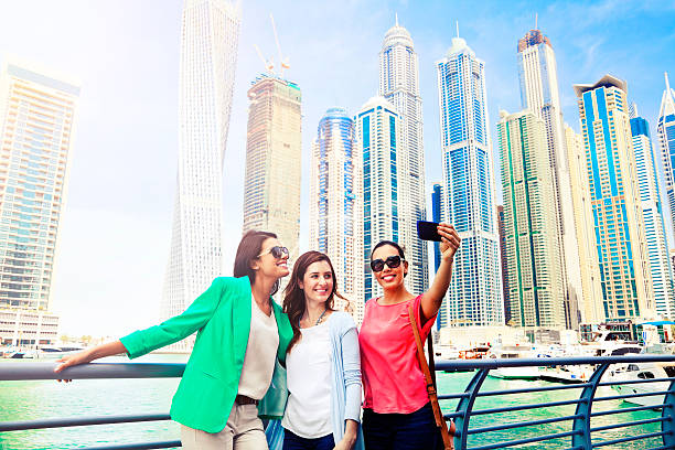 Three women take selfie in Dubai Marina stock photo