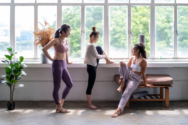 ba phụ nữ trẻ châu á trung quốc thẳng thắn trò chuyện cười trong lớp yoga cổ phiếu ảnh - improve your psychology hình ảnh sẵn có, bức ảnh & hình ảnh trả phí bản quyền một lần
