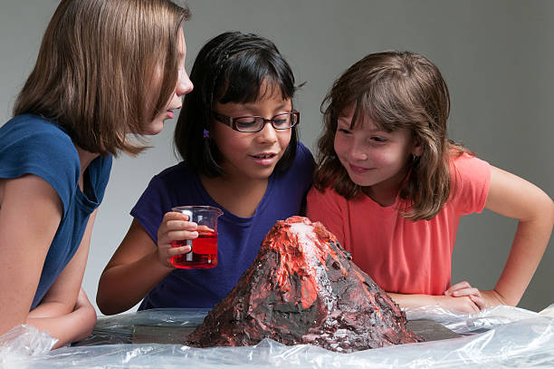Three young girls studying volcanoes stock photo