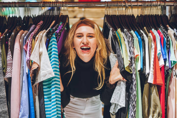 Thrift shopping is all the rage! Shot of a young woman shopping for clothes at a second hand store clothes rack stock pictures, royalty-free photos & images
