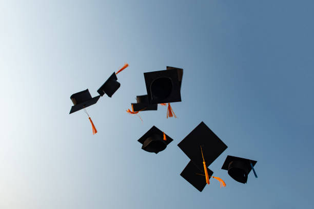 Throw a black hat of graduates in the sky. stock photo