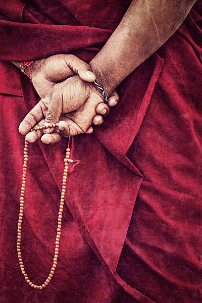 Tibetan Buddhism Vintage retro effect filtered hipster style travel image of Tibetan Buddhism - prayer beads in Buddhist monk hands with grunge texture overlaid. Ladakh, India tibetan ethnicity stock pictures, royalty-free photos & images