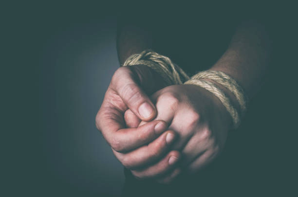 Tied hands Man with tied hands in low key hands tied up stock pictures, royalty-free photos & images