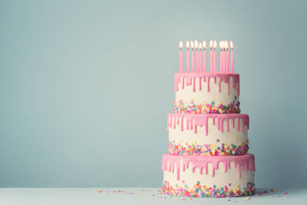 Tiered birthday cake Tiered birthday cake with drip frosting and twelve candles birthday cake stock pictures, royalty-free photos & images