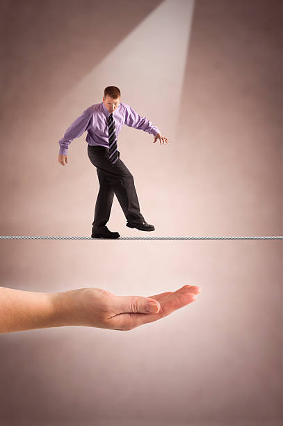 Tightrope over hand of safety stock photo