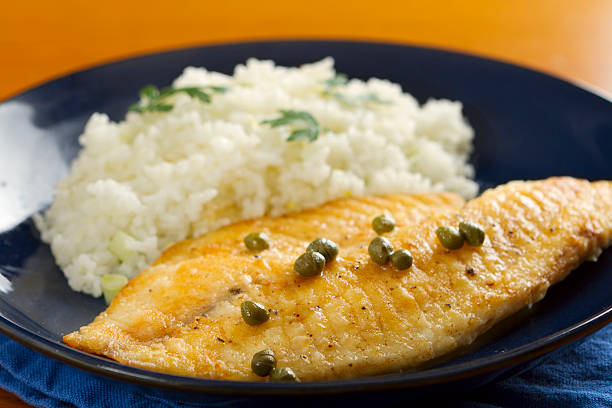 Tilapia and Lemon-Caper Sauce "Fresh pan seared tilapia  with a caper and lemon pan sauce, served with lemon infused rice." caper stock pictures, royalty-free photos & images
