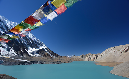 Tilicho lake, with 4920m above sea level one of the highest lakes in the world. In the foreground bhuddist prayer flags.