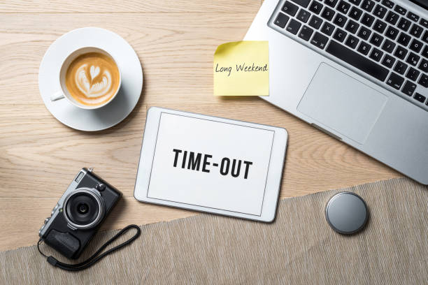 Time-out written on tablet in office as flatlay Time-out long weekend writings on tablet with camera, coffee mug and laptop lying on photography office desk as flat lay city break stock pictures, royalty-free photos & images
