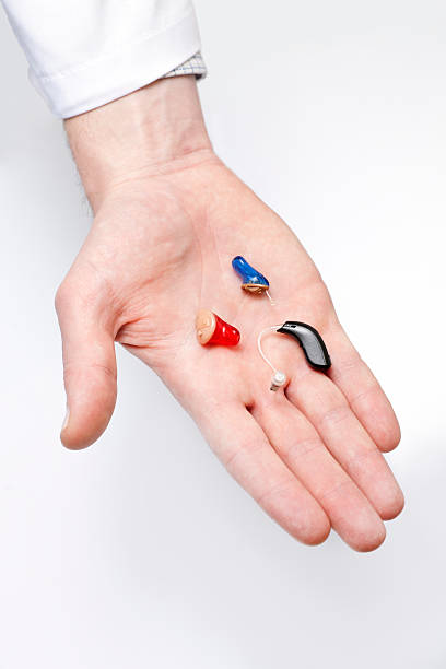 Tiny hearing aids on doctor's hand stock photo