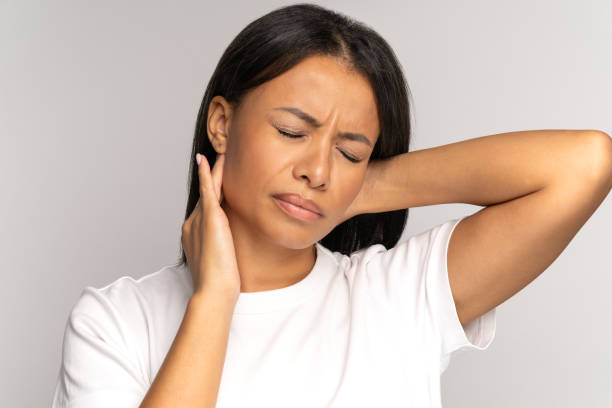 Tired african girl suffer from neck pain, spinal problem, incorrect posture, fibromyalgia. Neck ache stock photo