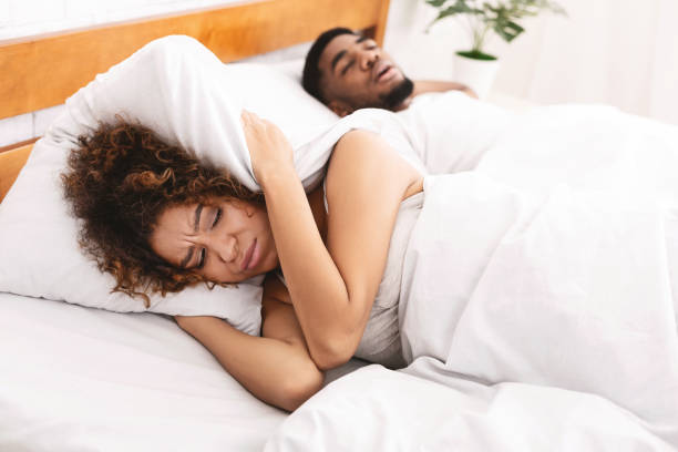tired and annoyed woman of her boyfriend snoring - sleeping couple imagens e fotografias de stock