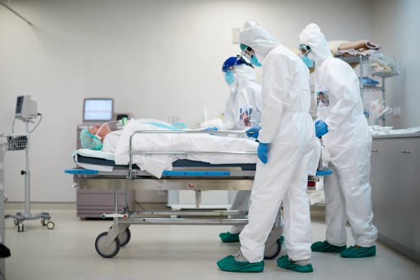 vermoeide en droevige gezondheidsarbeiders die een het ziekenhuisgurney duwen - dood fysieke beschrijving stockfoto's en -beelden