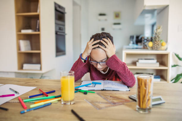 Tired boy doing his homework at the table Tired boy doing his homework at the table toughest exams stock pictures, royalty-free photos & images