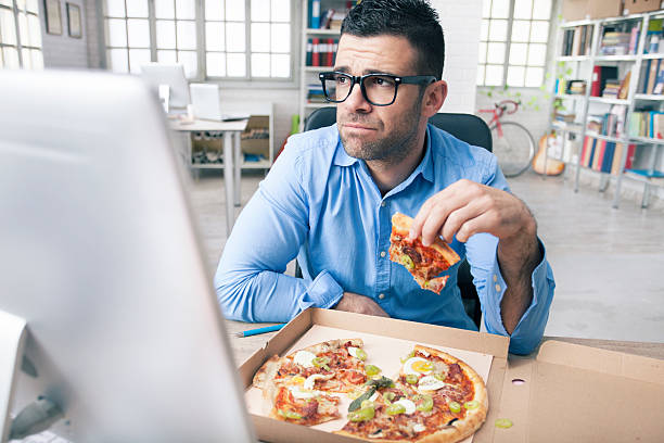 cansado empresário comer pizza no escritório - come e sente imagens e fotografias de stock