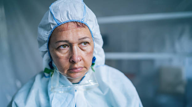 Tired Frontline Worker with protective suit during COVID-19 Tired Frontline Worker with protective suit during COVID-19 frontline worker stock pictures, royalty-free photos & images