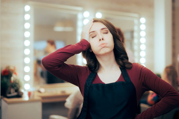 Tired Hairdresser Having a Hard Day of Work in Hair Salon stock photo