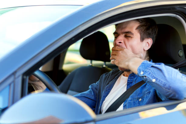 Tired man drives a car stock photo